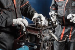 car restoration technicians dissembling a classic car engine