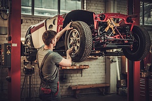 an auto mechanic performing a full car restoration at an auto body shop