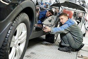 auto mechanic finishing a car restoration in a garage
