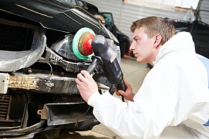 mechanic buffing the outside of a car in a full car restoration at an auto body and customs shop