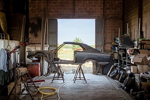 shell of a car to be restored in a garage