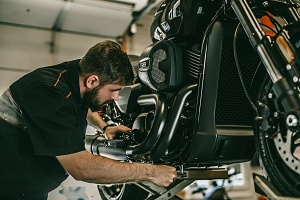 man assessing how much it is going to be to fix a custom motorcycle