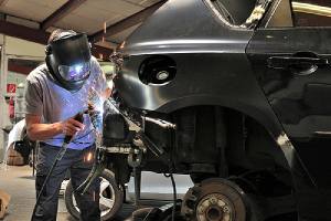 A custom auto body mechanic welding car body