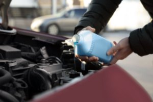 A man is changing the oil of his car as a part of preventive maintenance