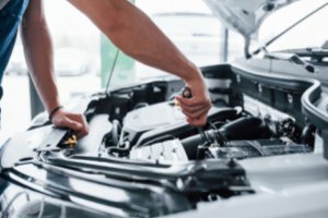 A mechanic is repairing a car's engine