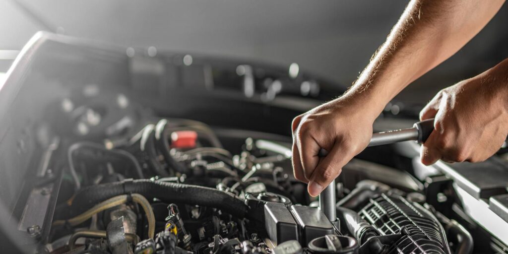 A car mechanic fixing up the engine of a car